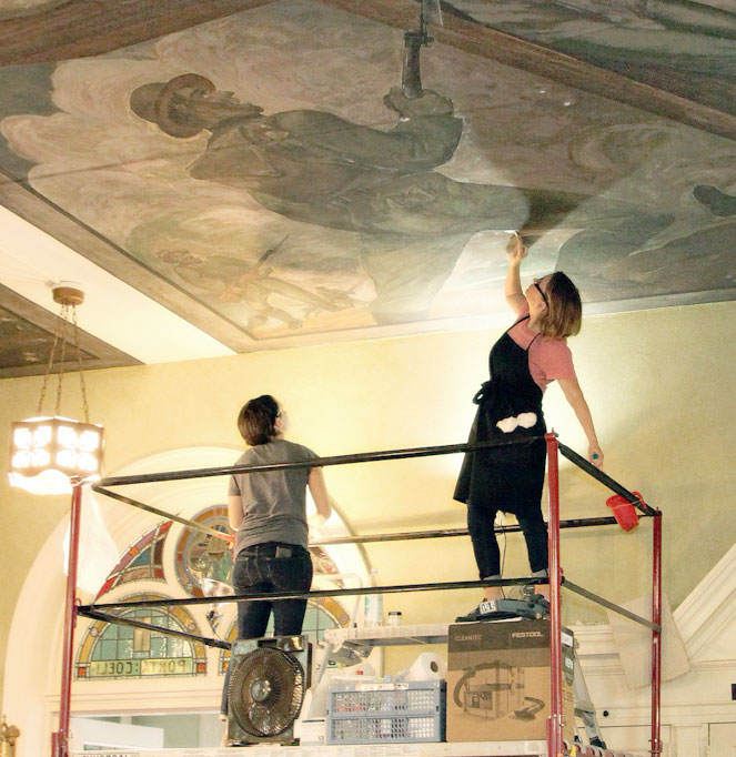 Conservator working on mural ceiling
